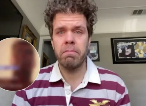 Perez Hilton looking serious with a simple background.