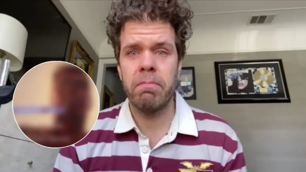 Perez Hilton looking serious with a simple background.