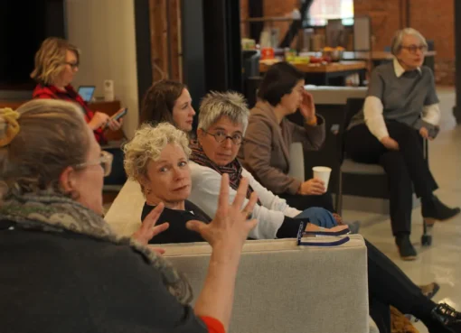 A diverse group of screenwriters collaborating and writing scripts at a lab intensive.