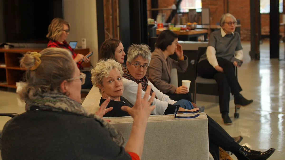 A diverse group of screenwriters collaborating and writing scripts at a lab intensive.
