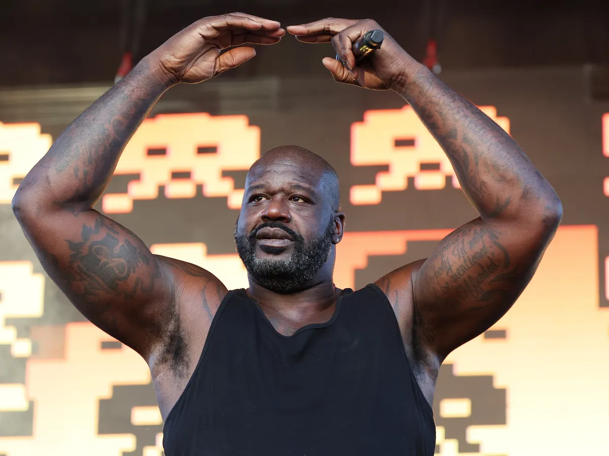 Shaquille O'Neal smiling, perhaps in a superhero pose or with a basketball.