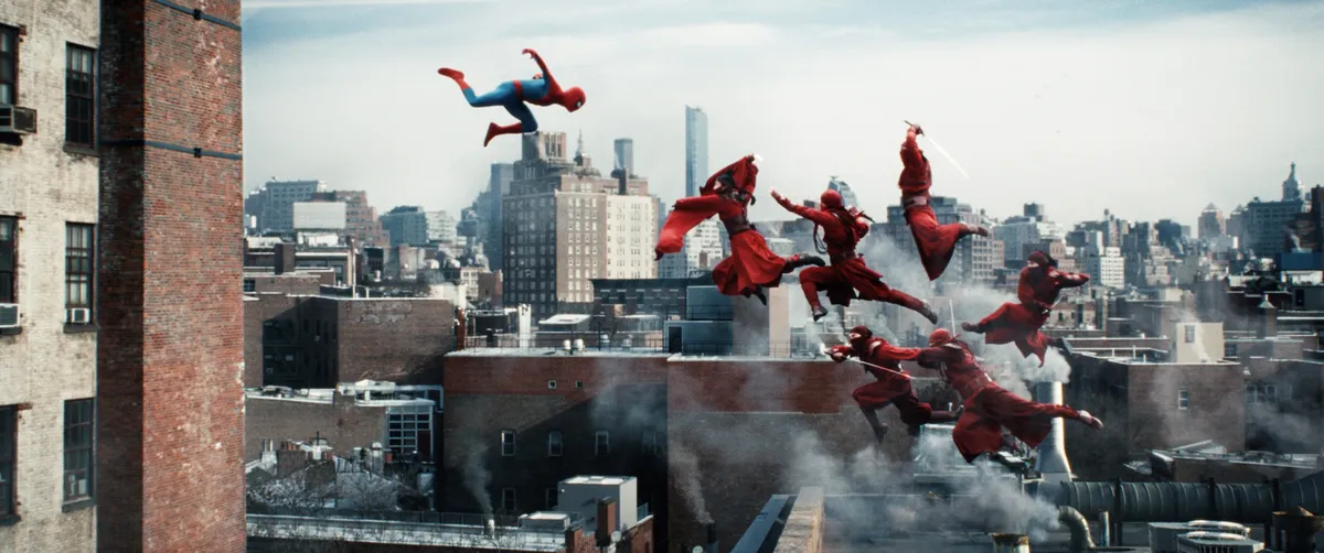 Spider-Man swinging through a vibrant city skyline during the day, with red and blue colors prominent.