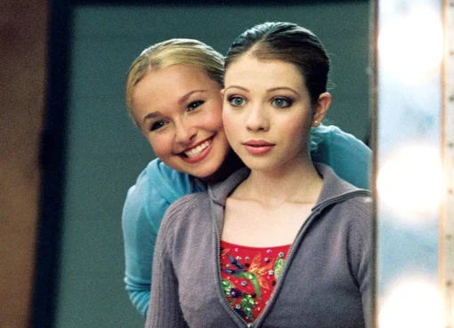Hayden Panettiere and Michelle Trachtenberg smiling brightly in their ice skating costumes from the movie 'Ice Princess'.