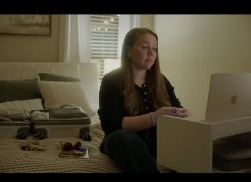 Kara Robinson Chamberlain looking directly at the camera with a serious yet determined expression, possibly in a dimly lit setting.