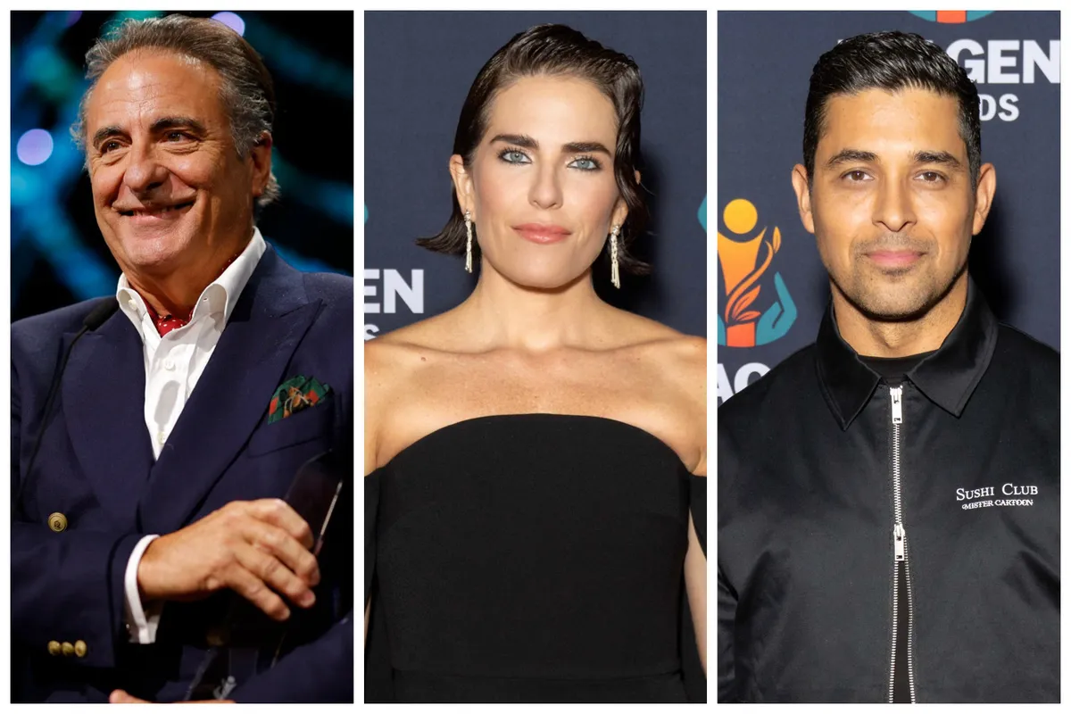Andy Garcia, Karla Souza, and Wilmer Valderrama smiling on a red carpet at an awards show.