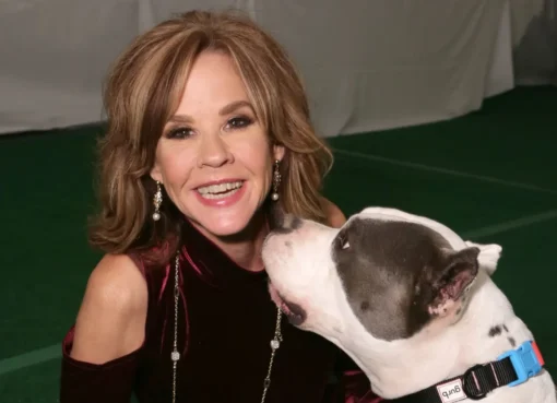 Linda Blair smiling with an animal, possibly a dog, at her rescue facility.