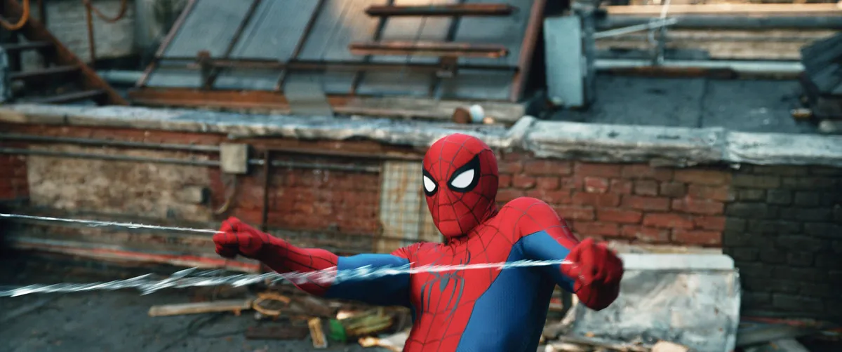 Spider-Man in his iconic red and blue suit, web-slinging through a city.
