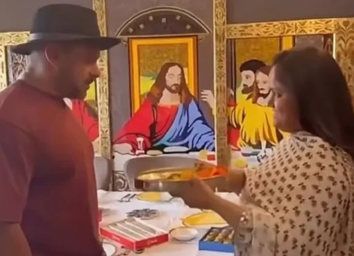 Arpita Khan Sharma tying Rakhi on Salman Khan's wrist in front of a colorful Jesus mural.