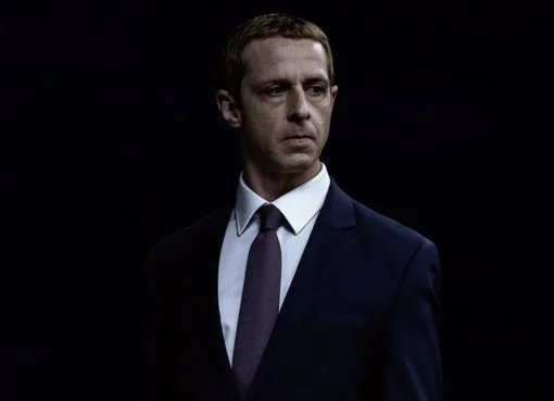 Jeremy Strong dressed as Mark Zuckerberg, looking serious and focused.