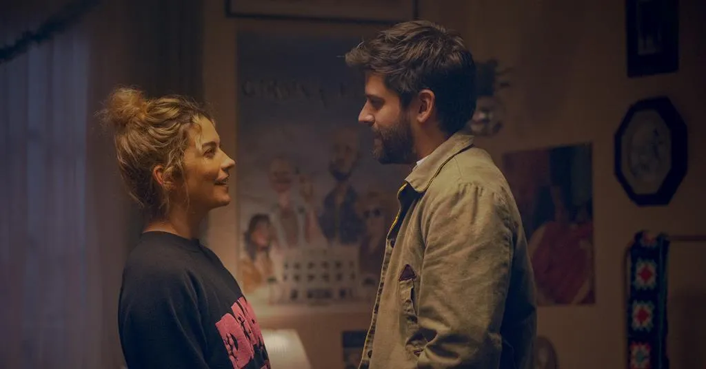 Annie Murphy and Cooper Raiff laughing together, looking like a well-matched romcom duo.
