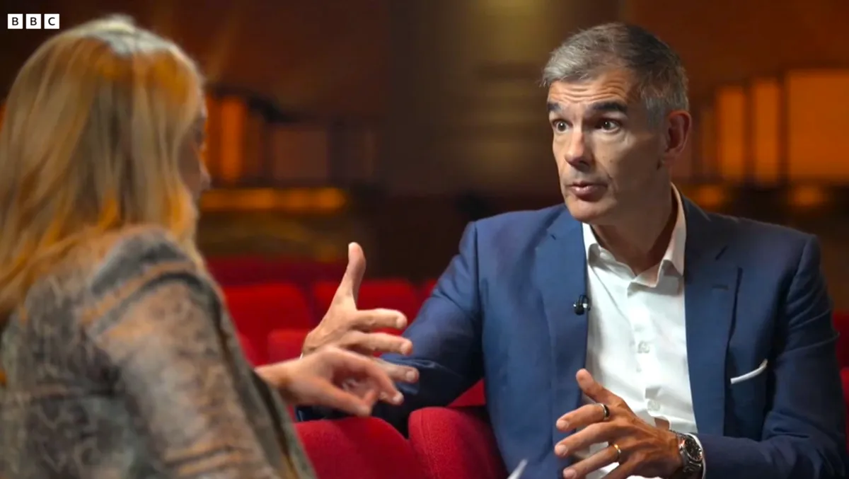Matt Brittin, the director-general of the BBC, is speaking into a microphone during an interview.