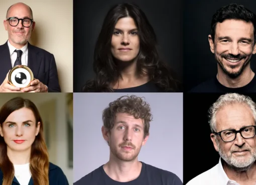 A photo of prominent film industry figures smiling at a conference.