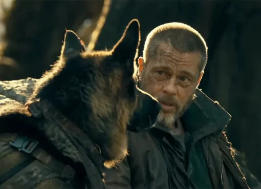Brad Pitt looking determined alongside a German Shepherd dog in a wild, snowy forest.
