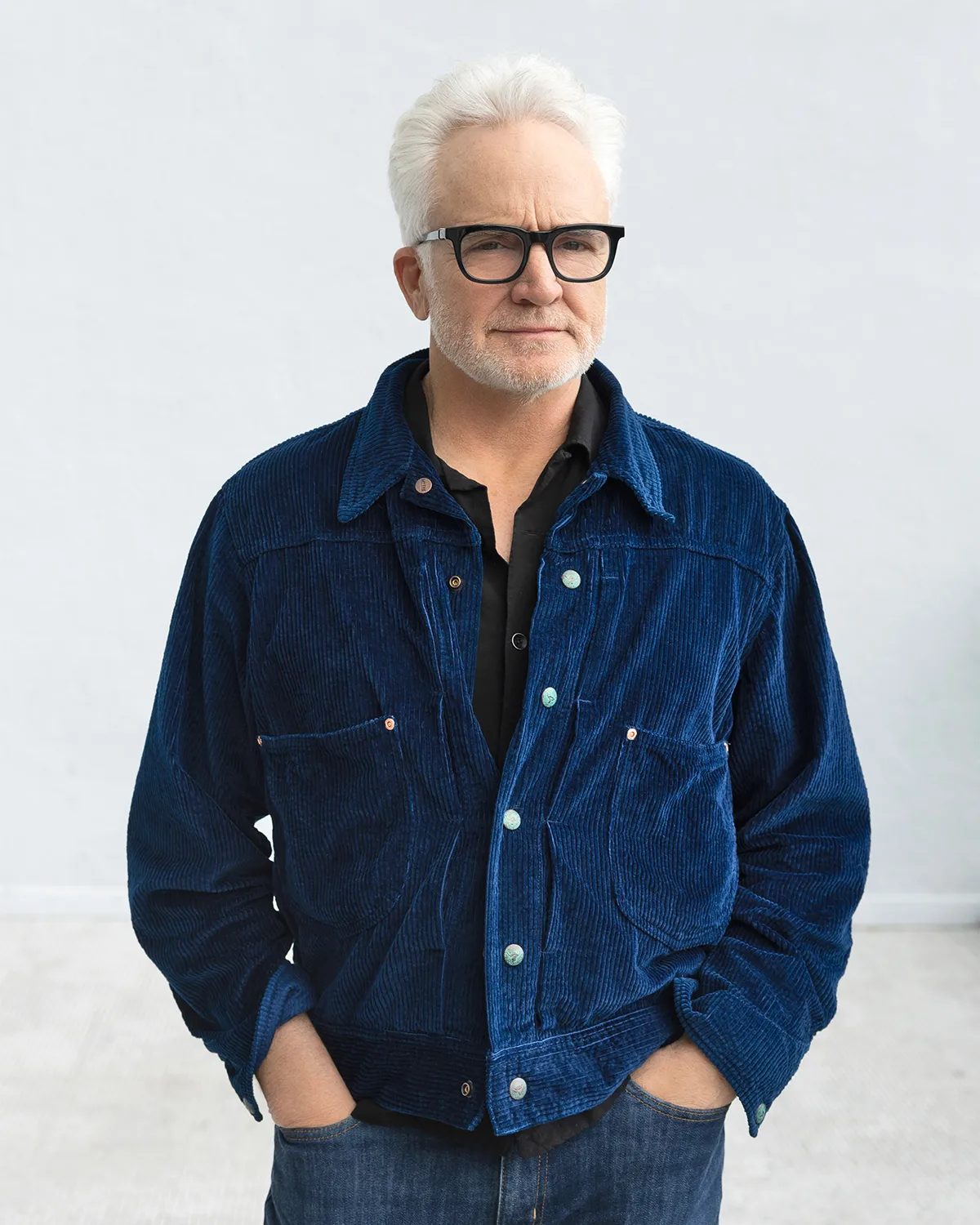 Bradley Whitford smiling on a Broadway stage under a warm spotlight.