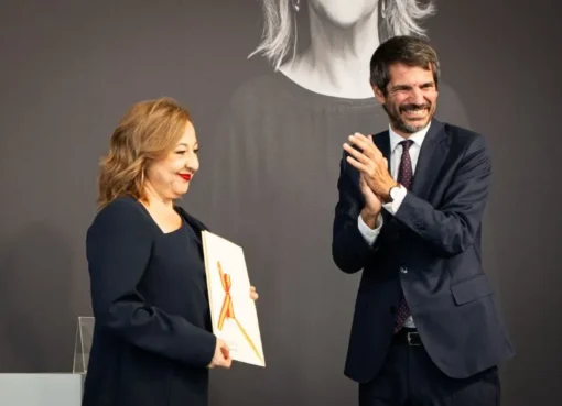 Carmen Machi smiling brightly while holding a prestigious award at a film festival.