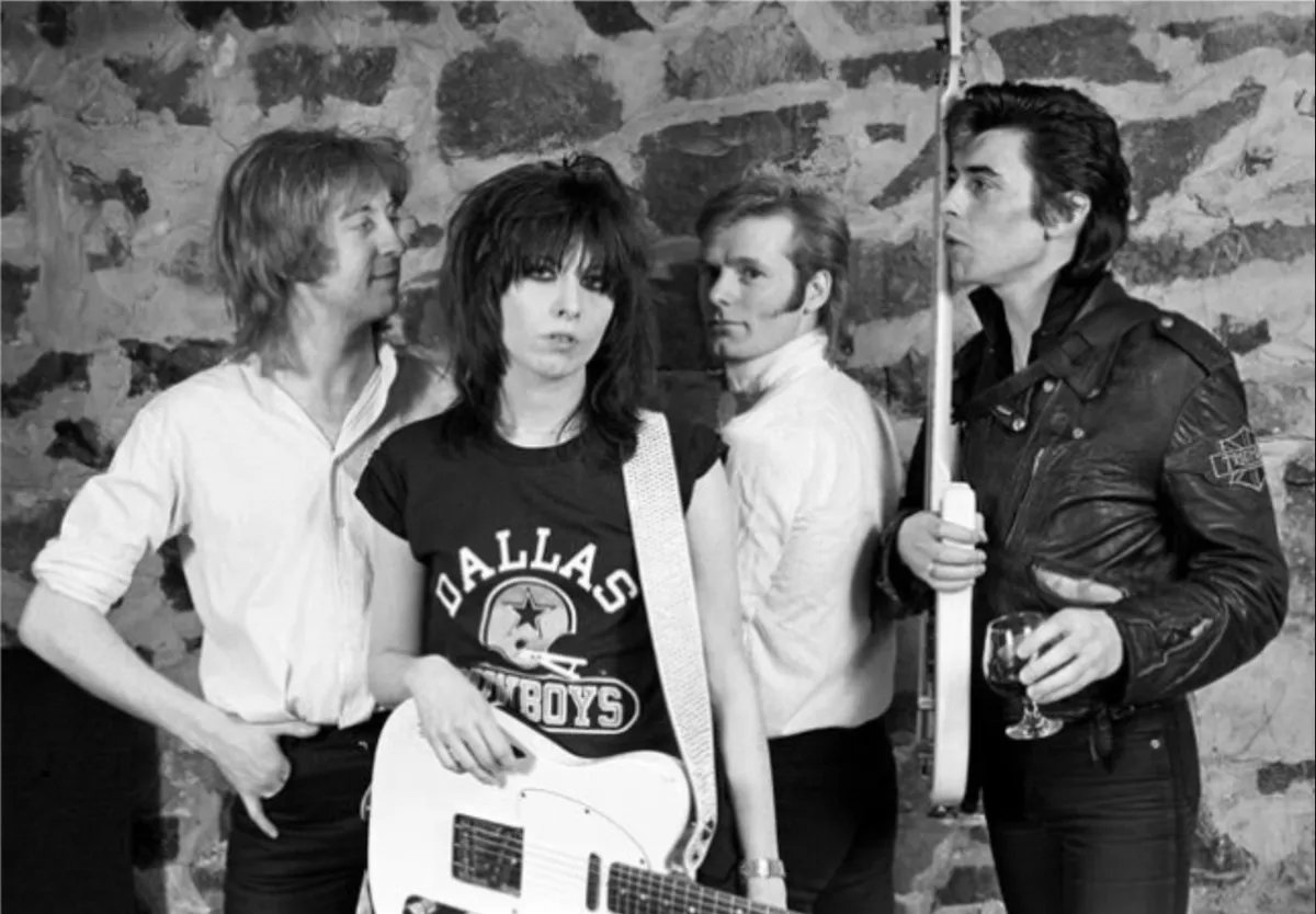 Close-up shot of Chrissie Hynde with dark eye makeup and a serious expression, embodying a punk rock aesthetic.