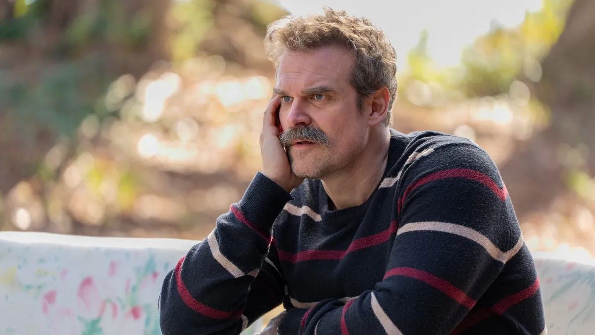 David Harbour holding his Emmy award.
