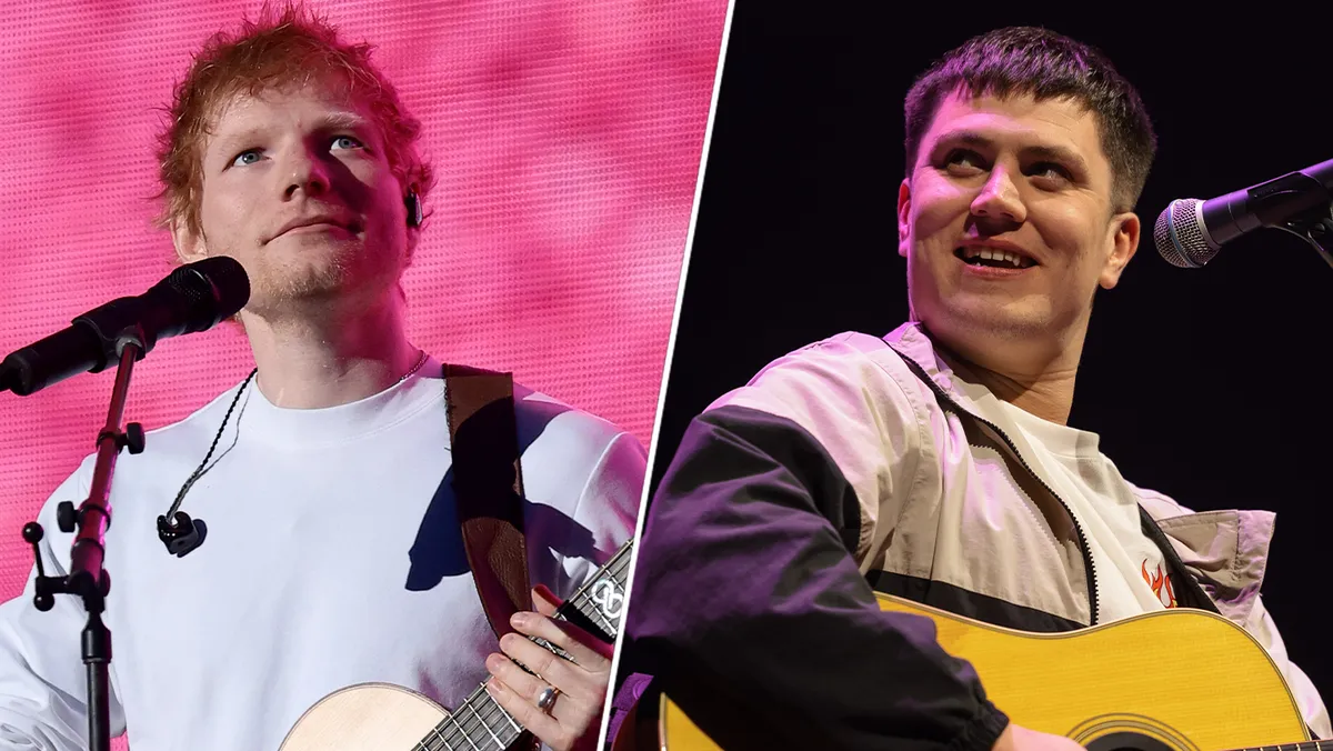 Singer Ed Sheeran performing on stage with guitar.