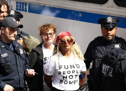 Protestors holding signs with police in the background.
