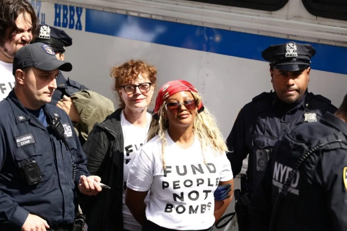 Protestors holding signs with police in the background.