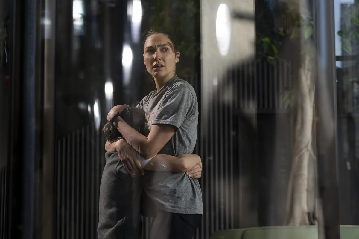 Gal Gadot looking determined and running on a London street.