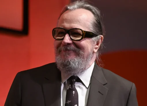 Gary Oldman looking thoughtful, perhaps in a suit.