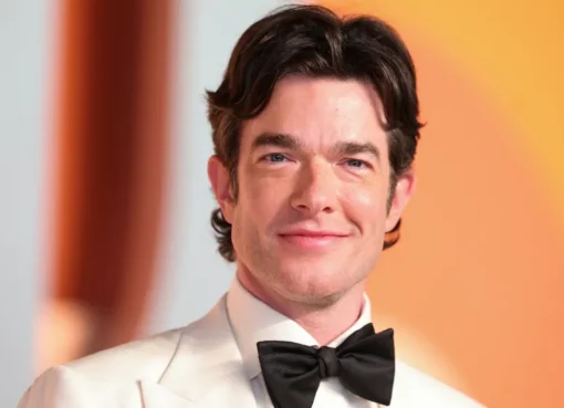 John Mulaney smiling on stage.