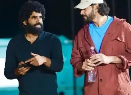 SS Karthikeya looking upset backstage at an event with a screen displaying technical glitches.