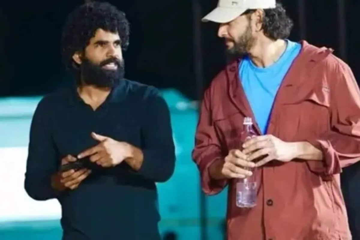 SS Karthikeya looking upset backstage at an event with a screen displaying technical glitches.