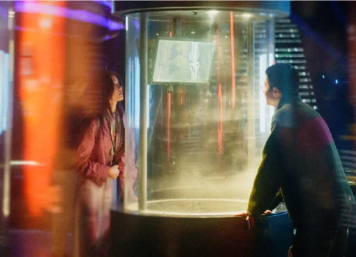 A still from 'Zoom In, Zoom Out' showing a contemplative young man, Shi, a game designer, looking into an empty space, possibly a room.