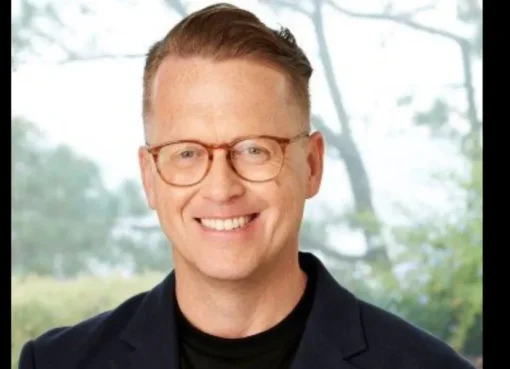 Noel Hedges smiling in a professional setting.