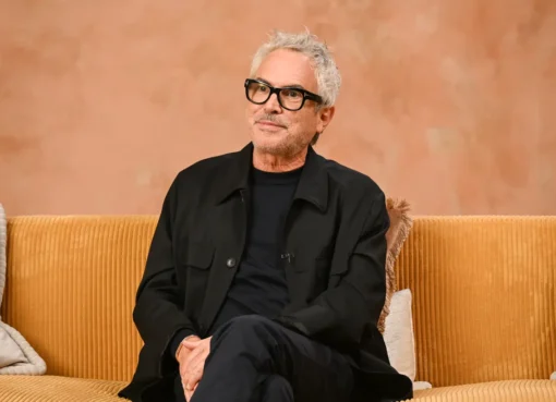 Alfonso Cuarón with film reels, surrounded by a vibrant film festival crowd.