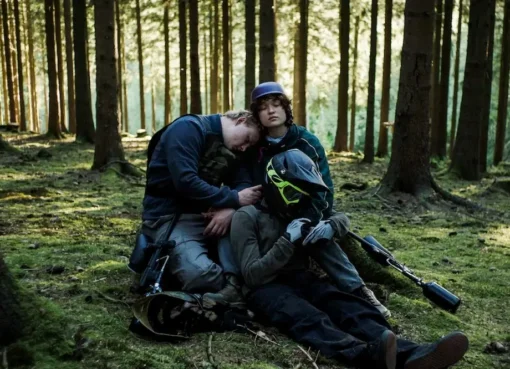 Three teenagers walking into a dark, dense forest.