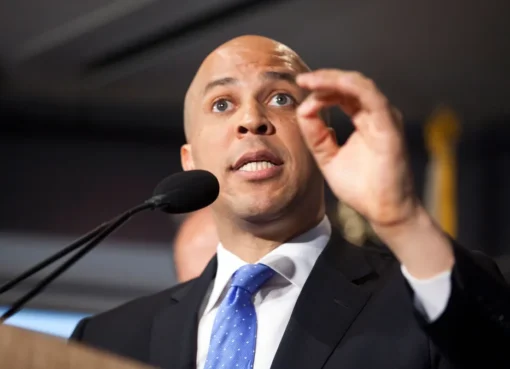 Senator Cory Booker looking serious and focused, perhaps giving a speech or addressing reporters.
