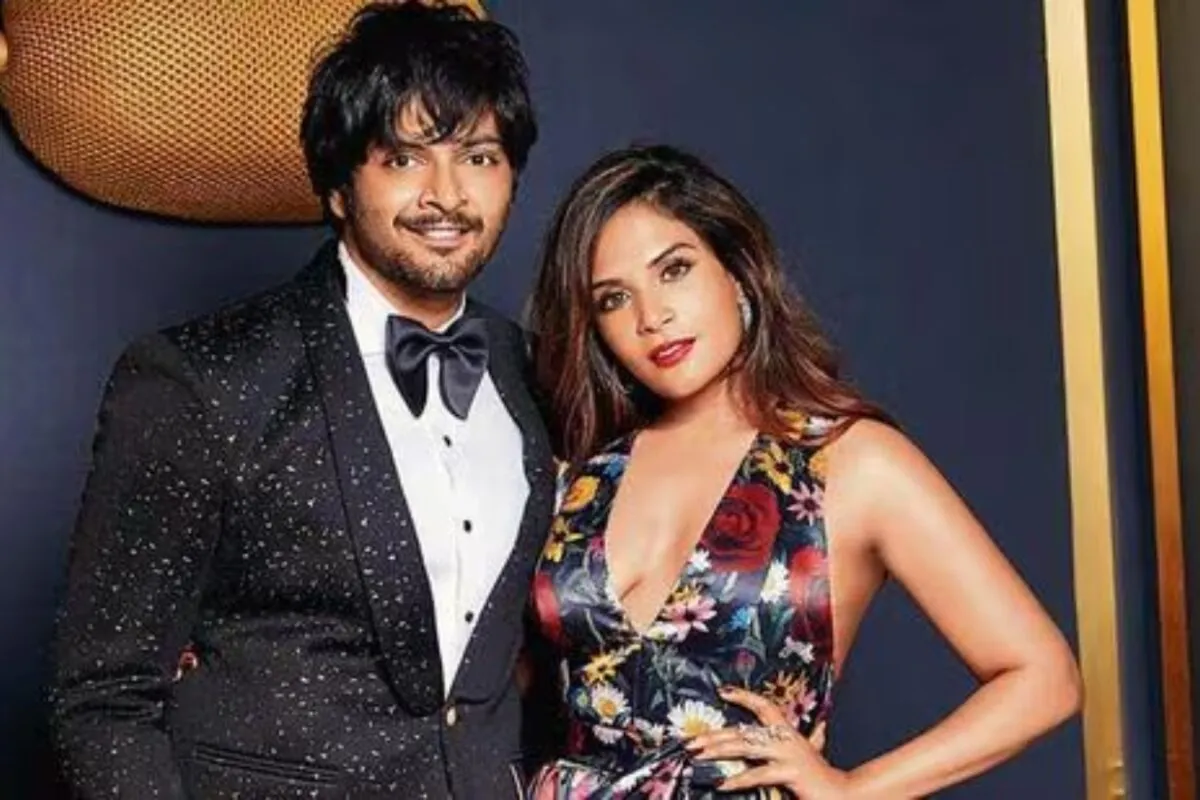 Richa Chadha and Ali Fazal smiling together at a movie premiere