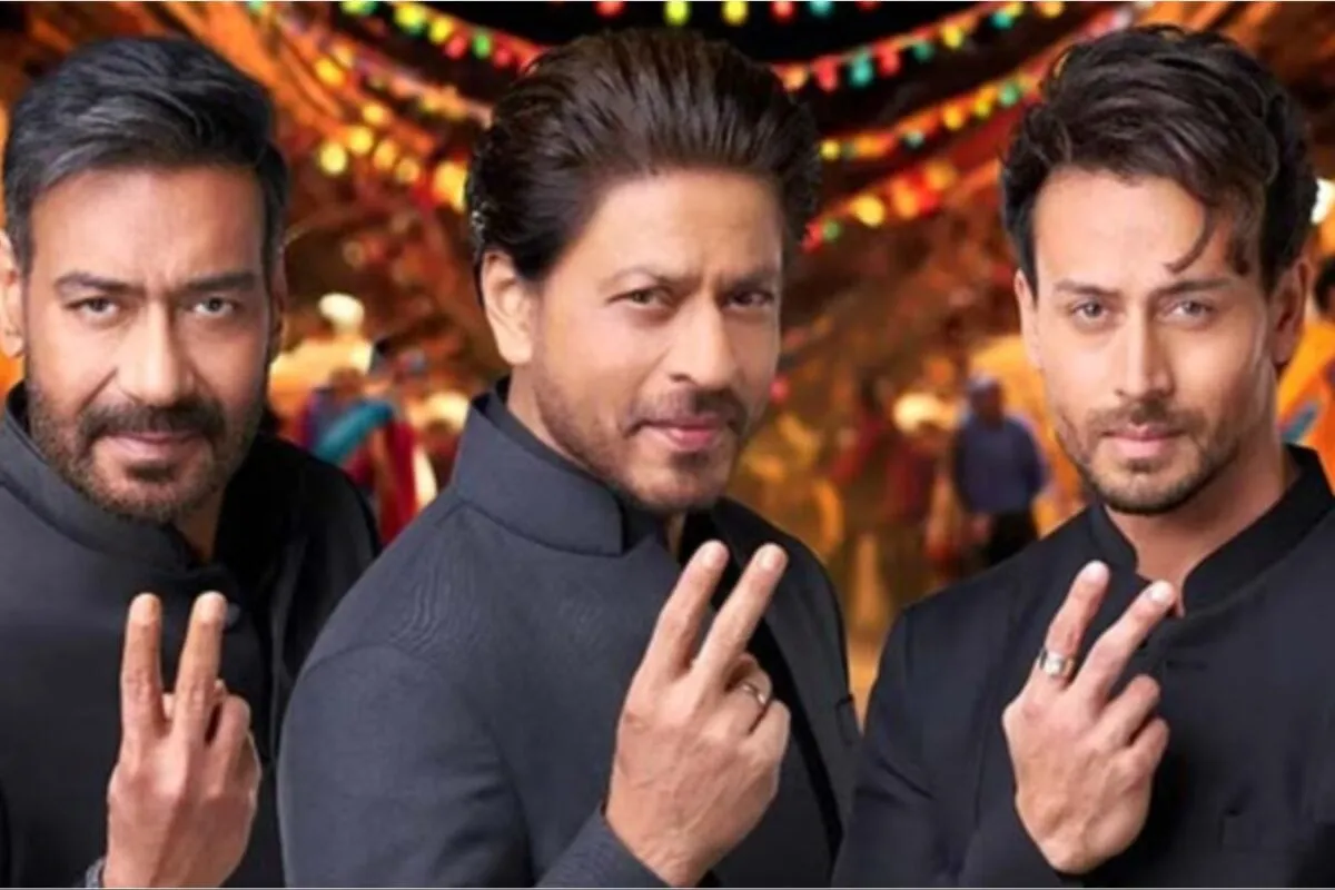 Shah Rukh Khan and Ajay Devgn at a public event looking serious.