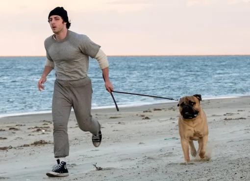 A cinematic shot of a young actor playing Sylvester Stallone on a 1970s movie set
