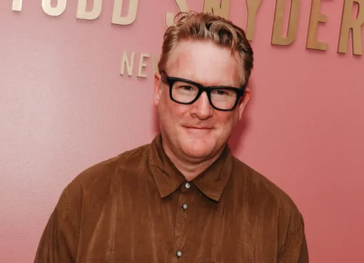 Fashion designer Todd Snyder smiling, perhaps with a subtle background featuring his stylish menswear.