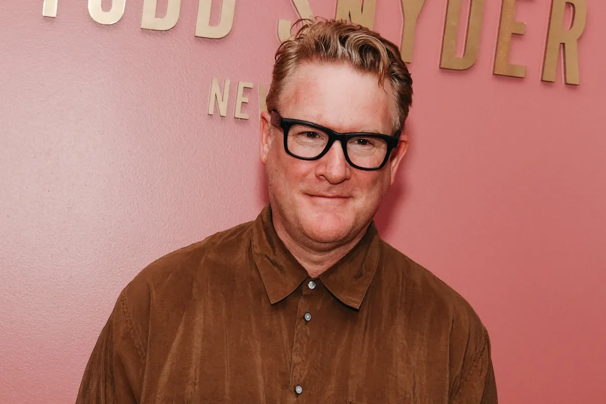 Fashion designer Todd Snyder smiling, perhaps with a subtle background featuring his stylish menswear.