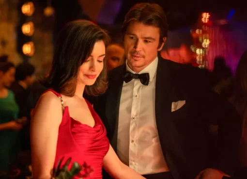 Dakota Johnson and Anne Hathaway looking serious in a dimly lit scene from the movie 'Verity'.