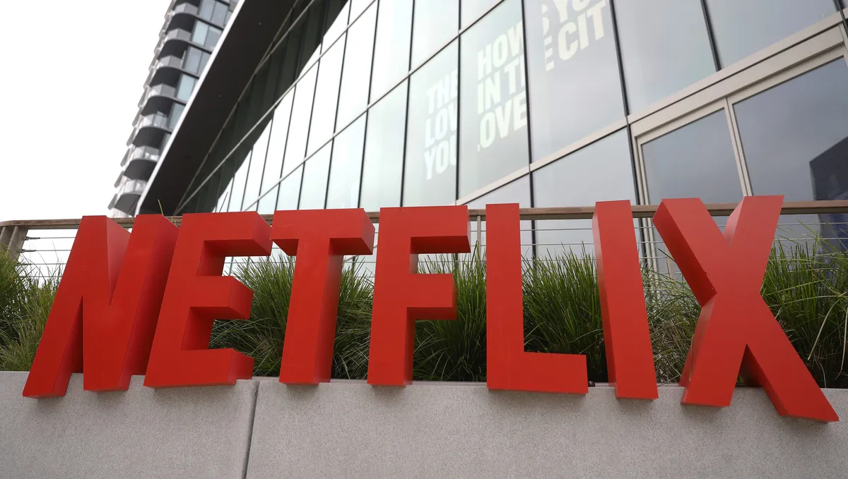 Netflix logo on a screen with a slight price tag overlay, representing a price increase.