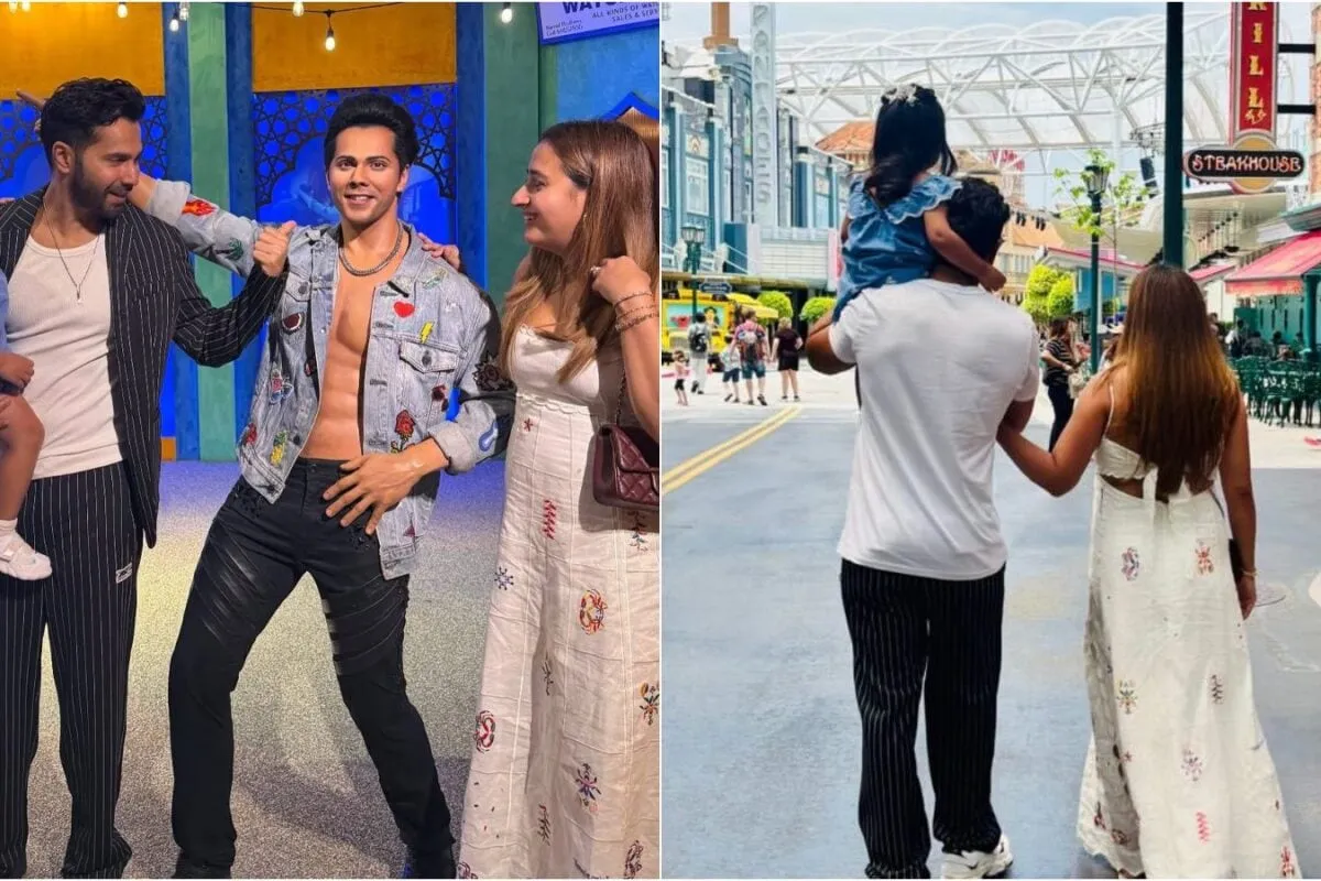 Varun Dhawan standing next to his wax figure while holding his daughter Lara.