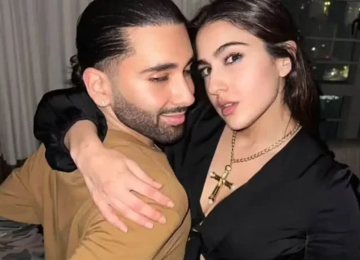 Orry and Sara Ali Khan posing together at a fancy event with bright camera flashes