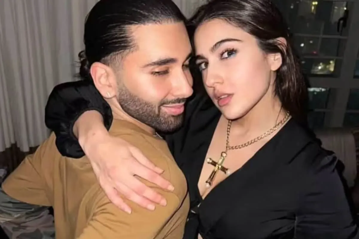 Orry and Sara Ali Khan posing together at a fancy event with bright camera flashes