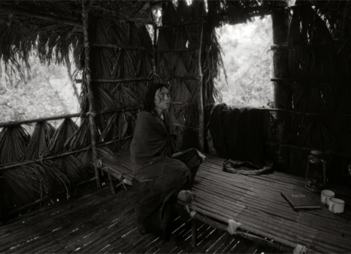 A black and white photo of filmmaker Lav Diaz, looking thoughtfully towards the side.