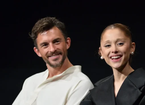 Ariana Grande and Jonathan Bailey smiling and looking surprised.
