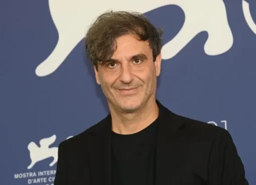 A serious-looking man, likely Alexandros Avranas, directing a film scene.