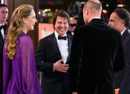 Tom Cruise smiling with Prince William and Princess Kate Middleton on a red carpet at the 'Digger' movie premiere.