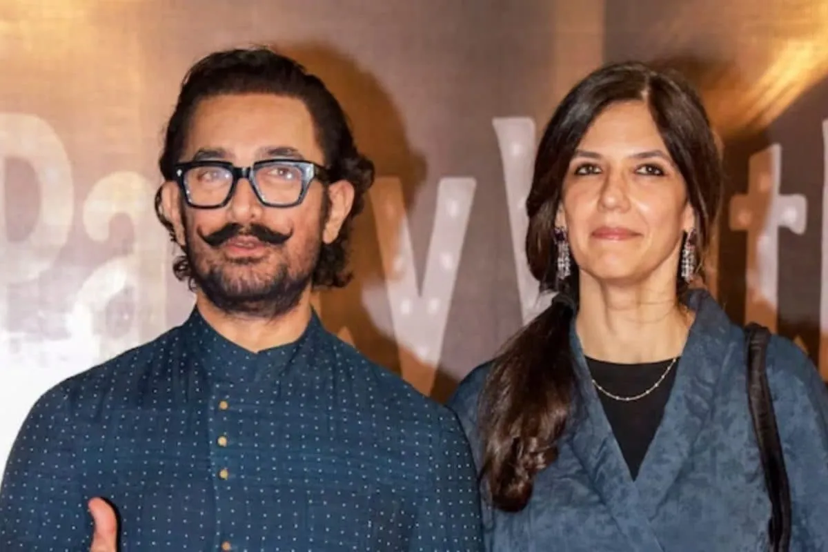 Aamir Khan and Gauri Spratt holding hands at a party.