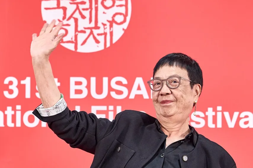 Ann Hui smiling at the Busan International Film Festival, holding her Camellia Award.